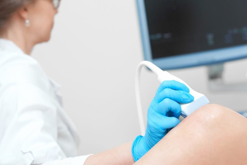 A high-resolution diagnostic ultrasound monitor displaying a detailed soft tissue scan next to a professional medical specialist in a private room at Beverly Hills Ultrasound Center.