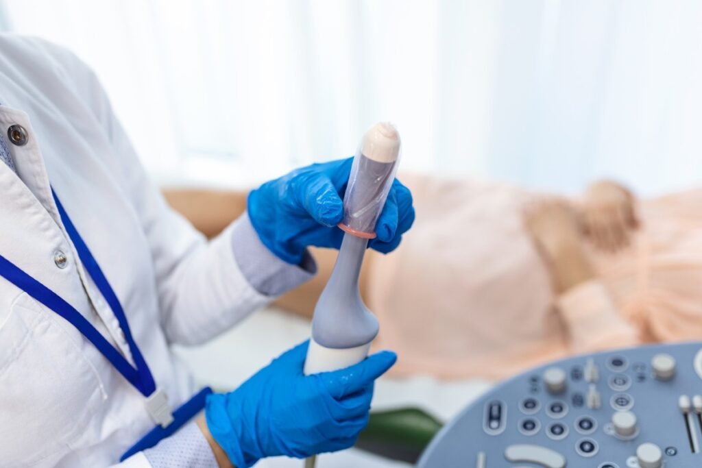 A medical sonographer preparing a slim transducer probe with gel, helping patients visualising the procedure size to address the question: is transvaginal ultrasound painful.