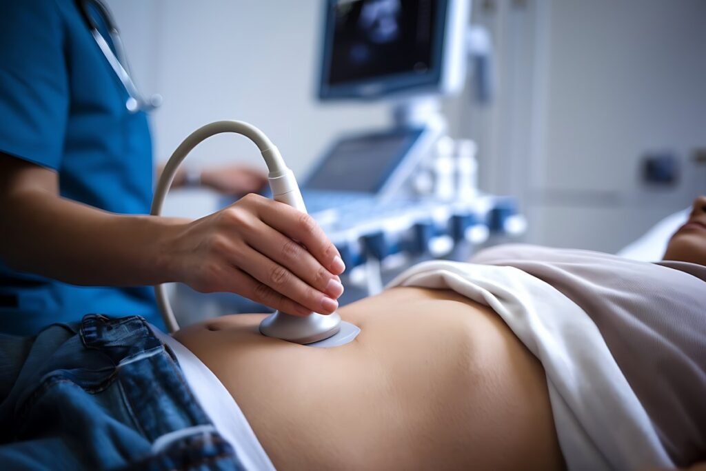 Close-up of a high-resolution medical monitor displaying internal organs alongside a sonographer's transducer, visually answering what diseases can be detected with abdominal ultrasound.